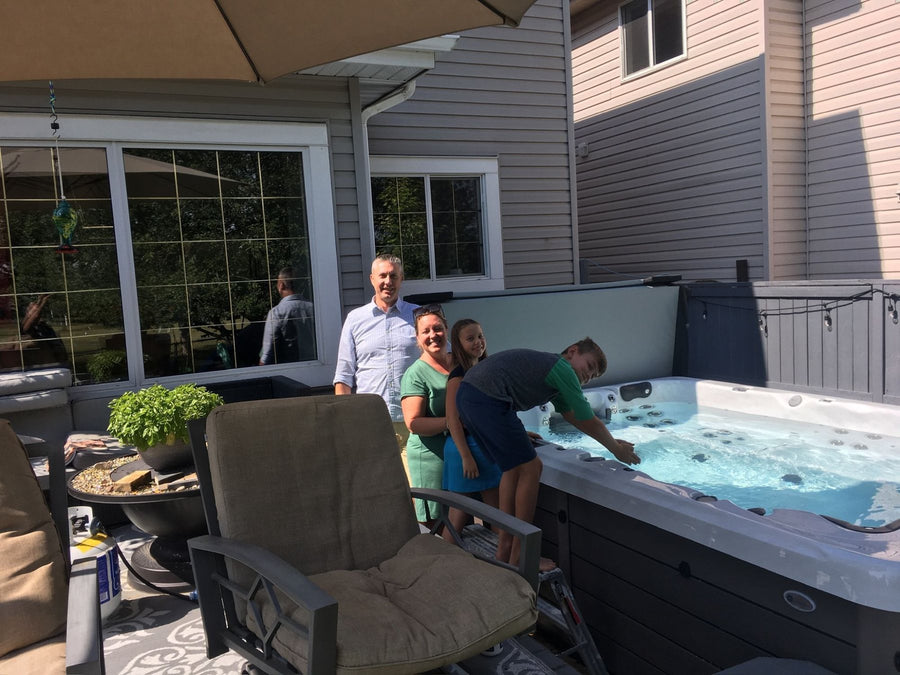 A family beside their hot tub on a summer afternoon