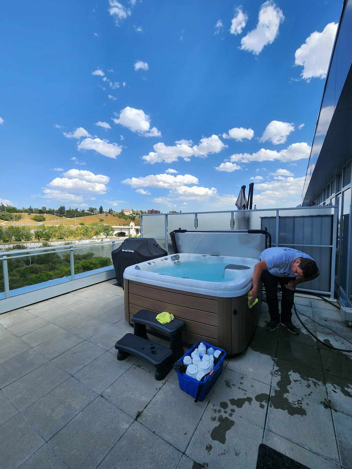 An RnR technician servicing a hot tub on a rooftop terrace