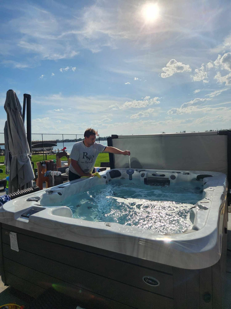 An RnR technician working on a hot tub on a rooftop in the evening sun