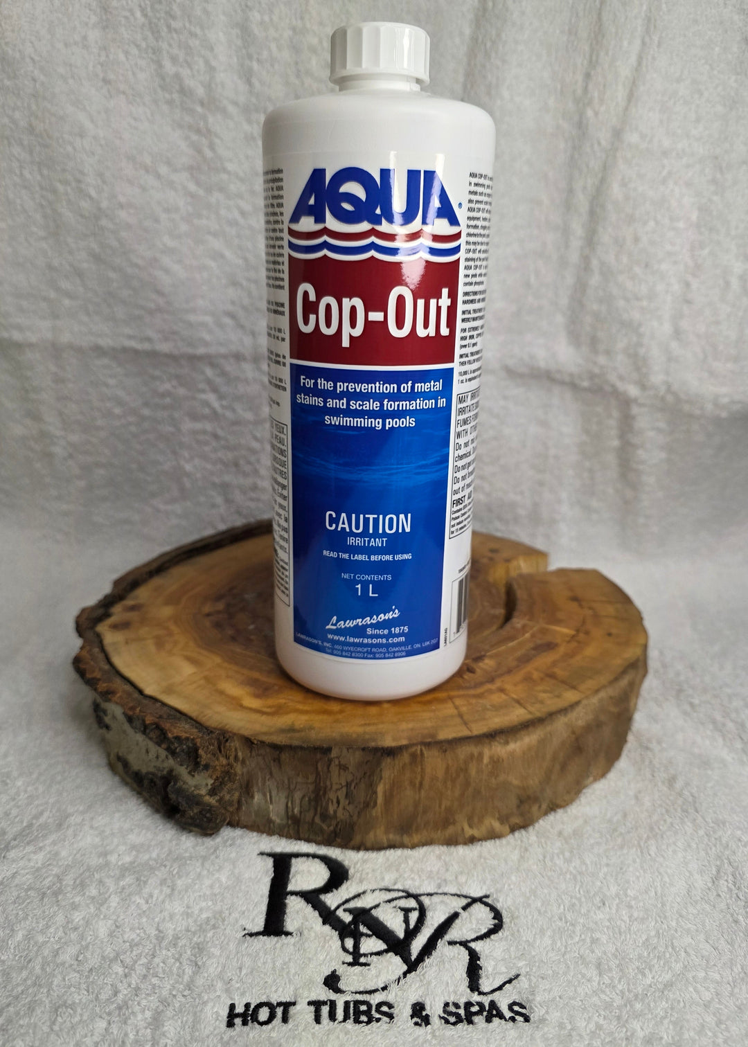 Aqua Cop-Out bottle on a wooden block with a gray background