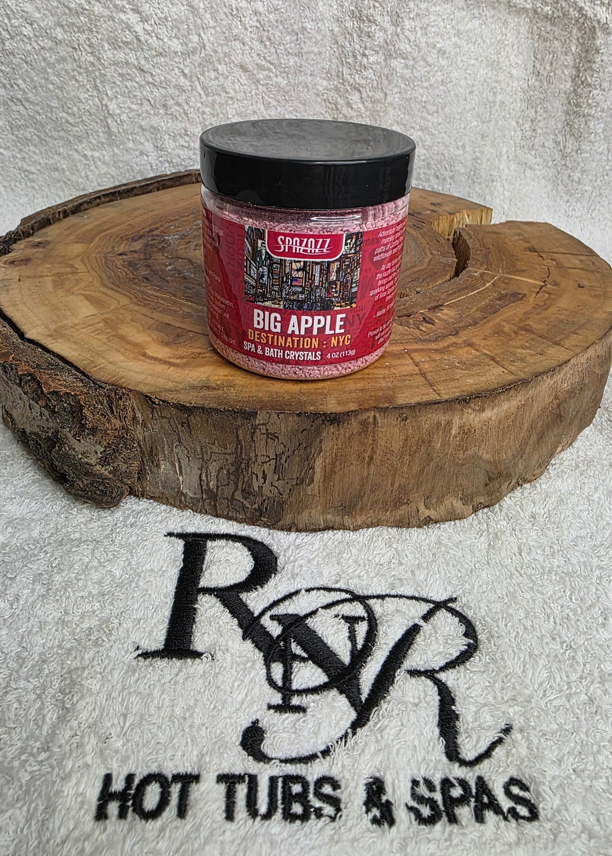 Spazazz Destinations Big Apple aromatherapy crystals on a wooden block with RnR Hot Tubs & Spas branding in the background.