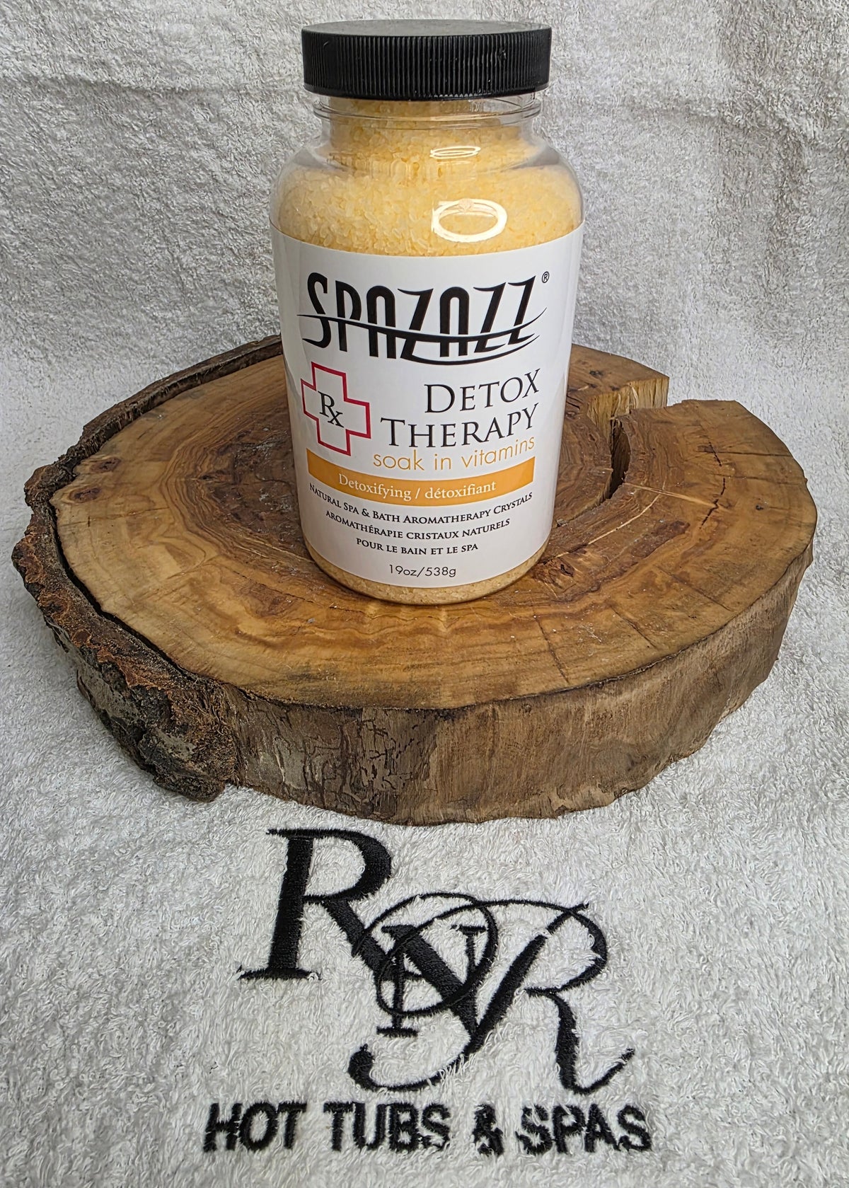 SpaZazz Detox Therapy product on a wooden block with RnR Hot Tubs & Spas branding in the background.