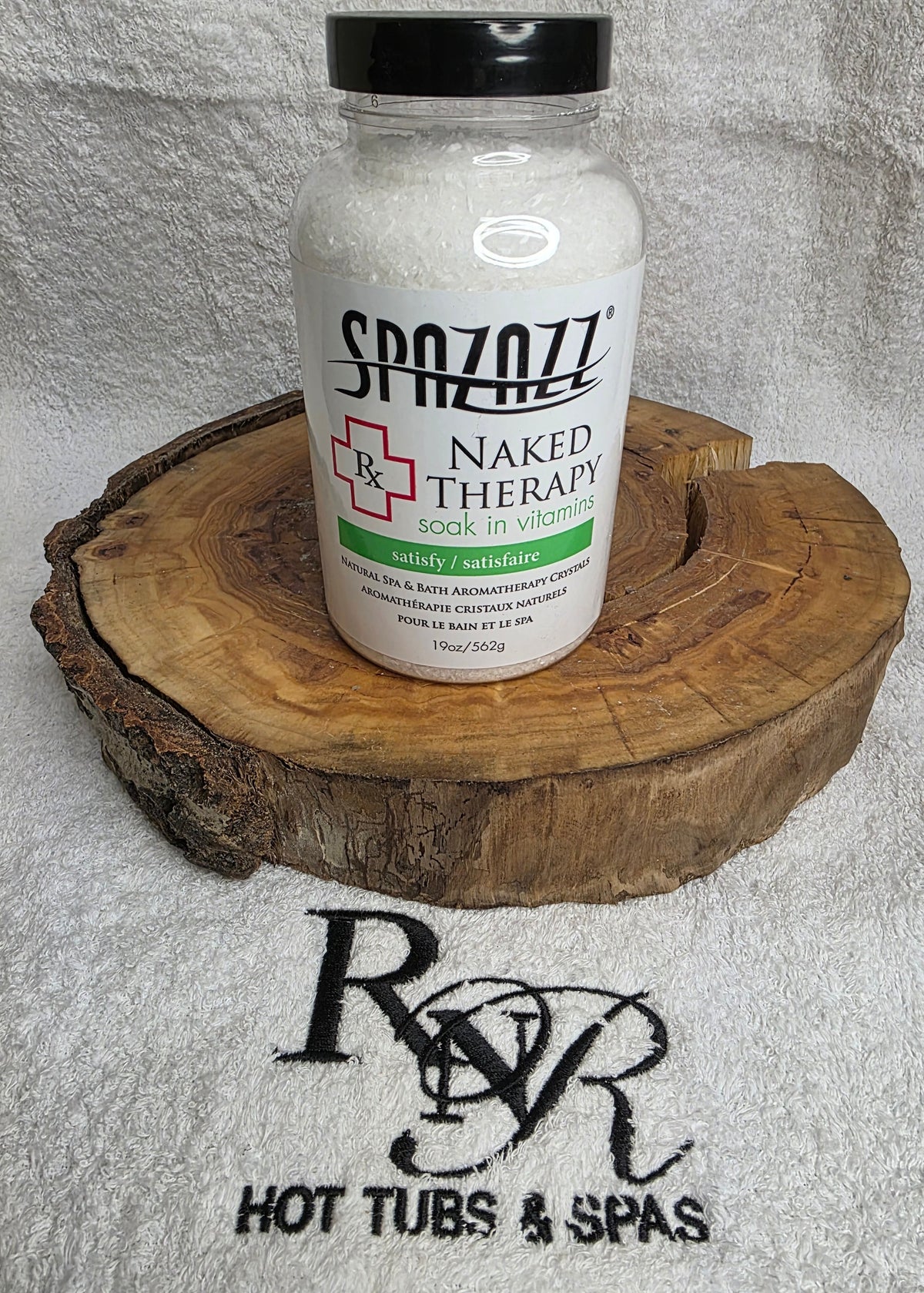 Bottle of Spazzazz Naked Therapy on a wooden block with RnR Hot Tubs & Spas logo in the background
