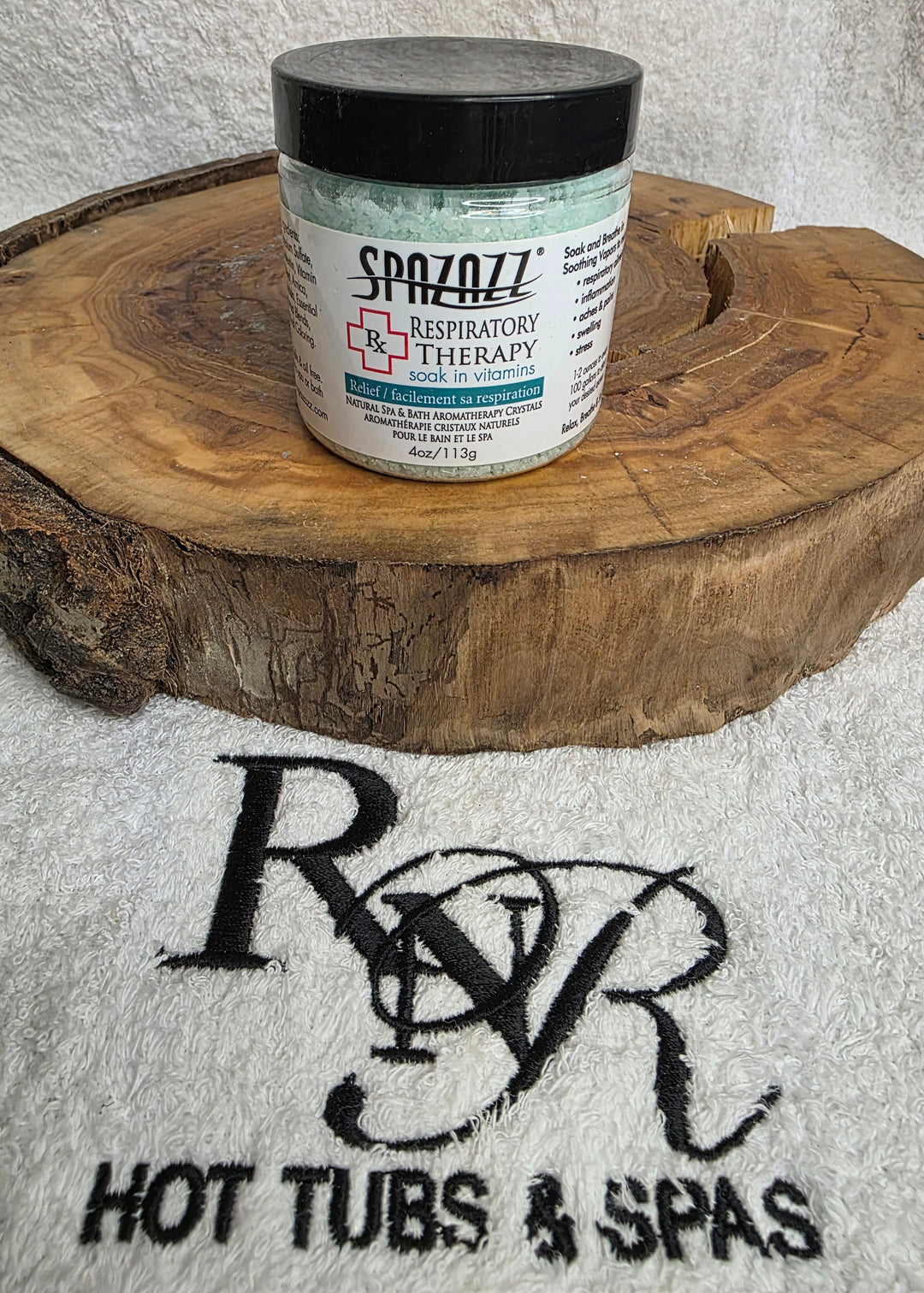 Container of Spazazz Respiratory Therapy aromatherapy crystals on a wooden block with RnR Hot Tubs &amp; Spas logo in the background