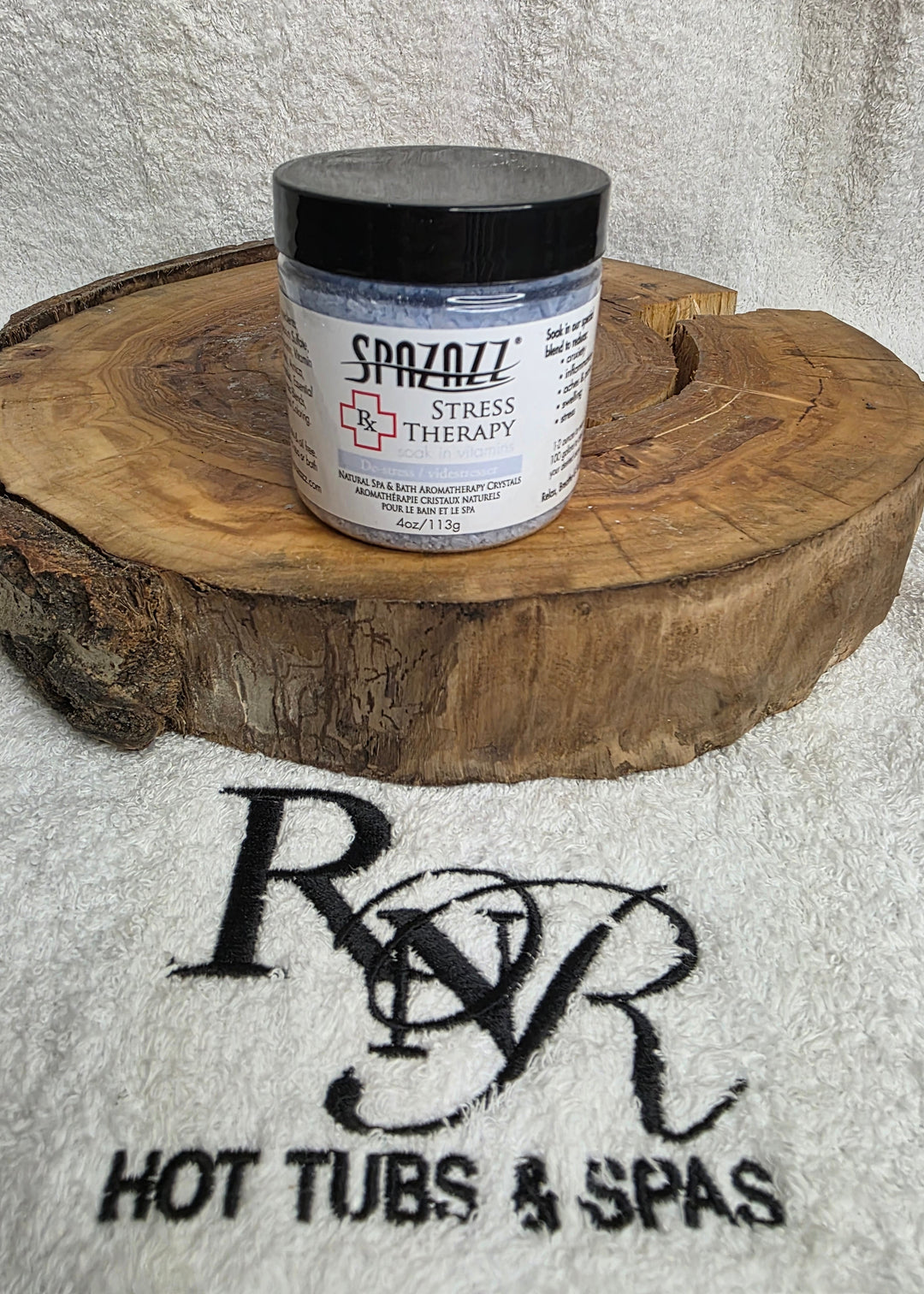 Spazazz Stress Therapy aromatherapy crystals on a wooden block with RnR Hot Tubs &amp; Spas logo in the background