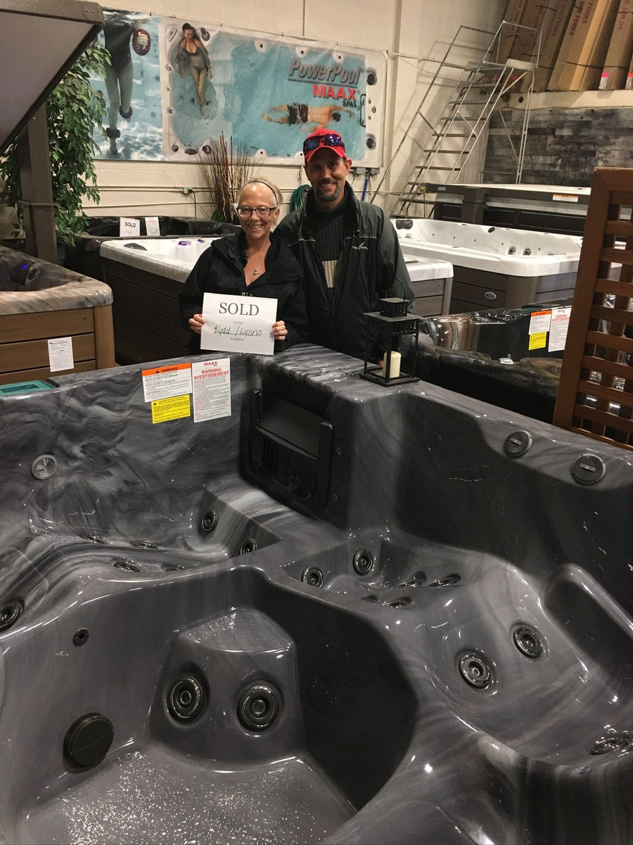 Customers at the showroom with the sold sign for their spa