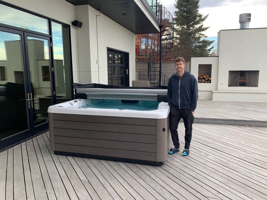 A customer beside a hot tub on a back deck