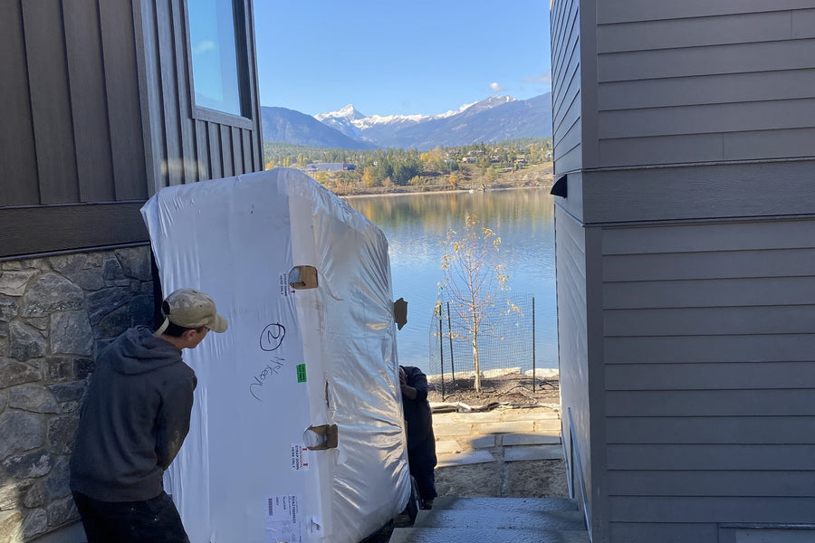 RnR crew moving a wrapped spa down the side of a house