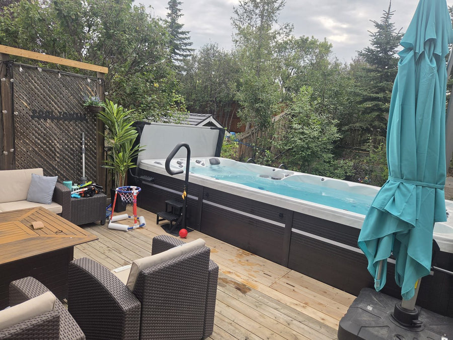 A swim spa set into a cedar deck with outdoor lounge seating