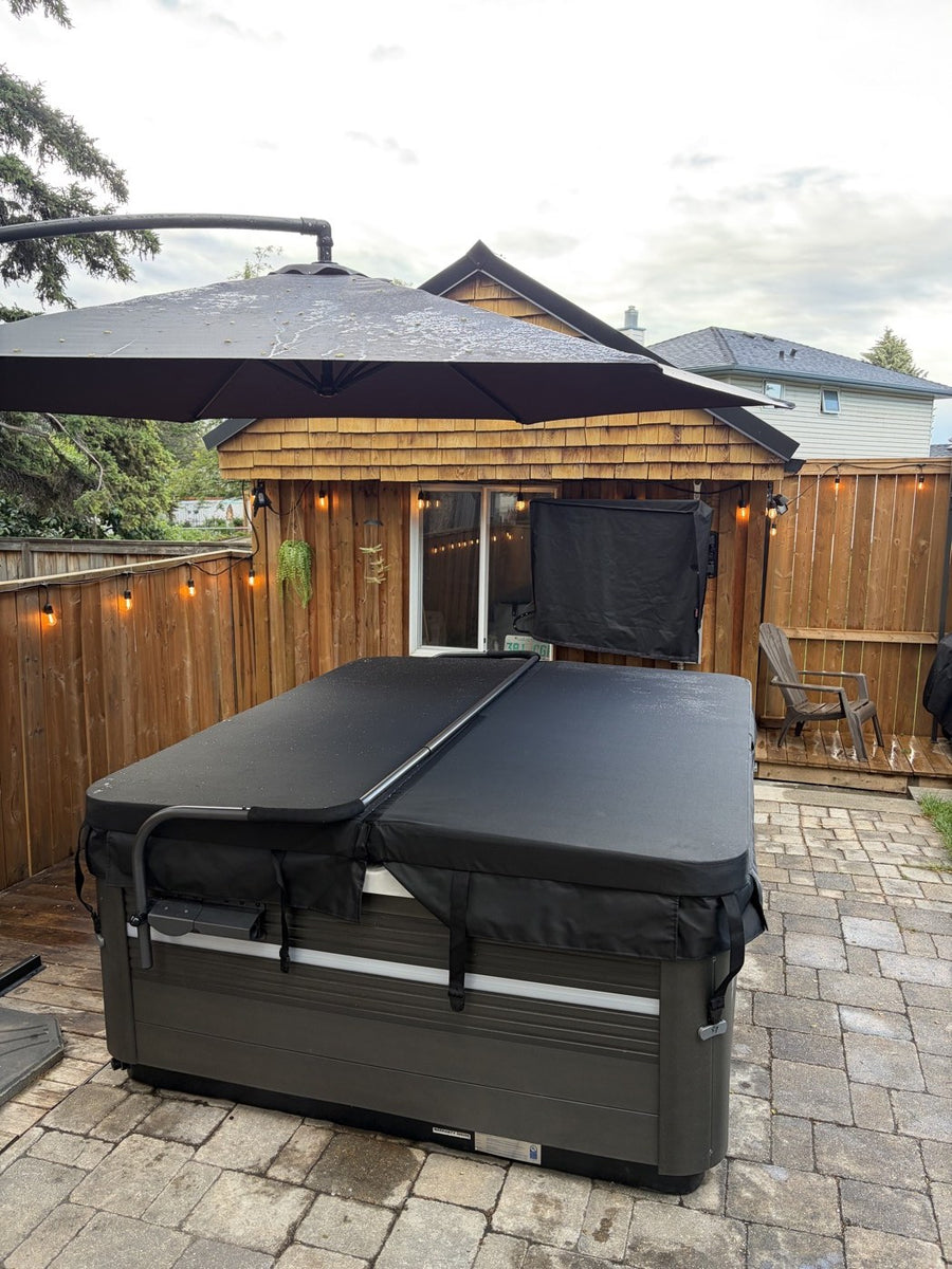 A covered hot tub beside a stone wall