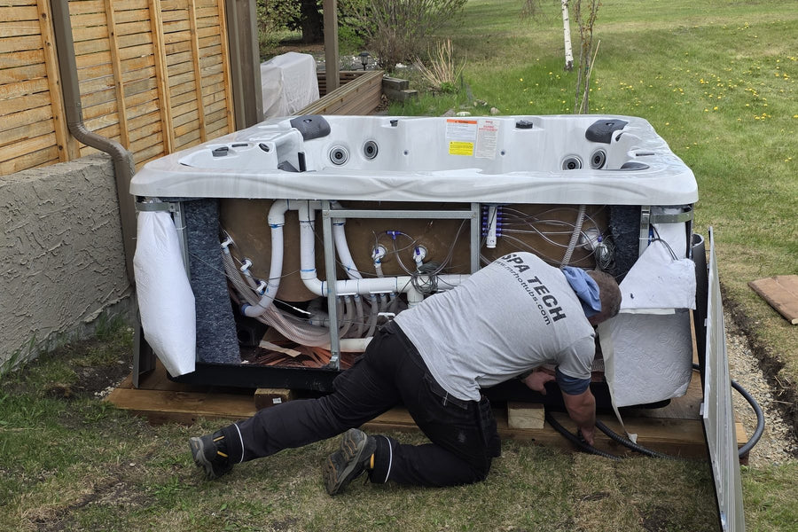 An RnR technician repairing a hot tub with its cabinet panels off