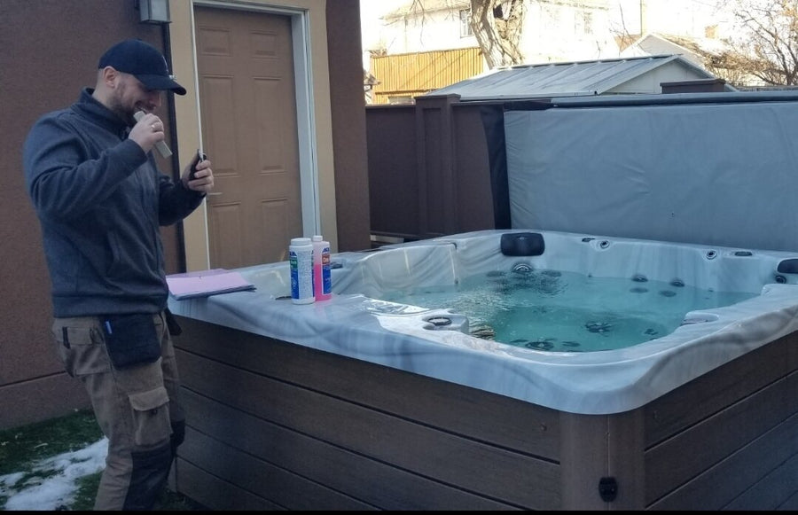 An RnR technician testing the water beside a hot tub