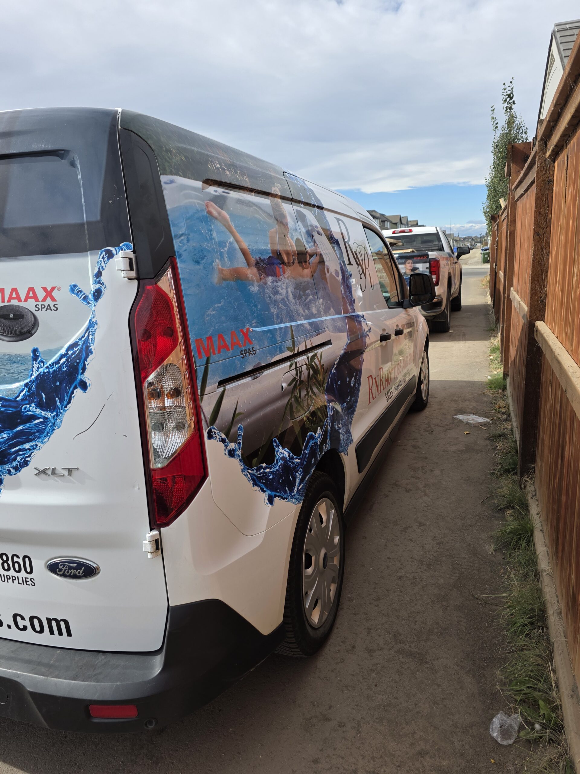 RnR Hot Tubs and Spas vehicles in an alley in Calgary, Alberta.