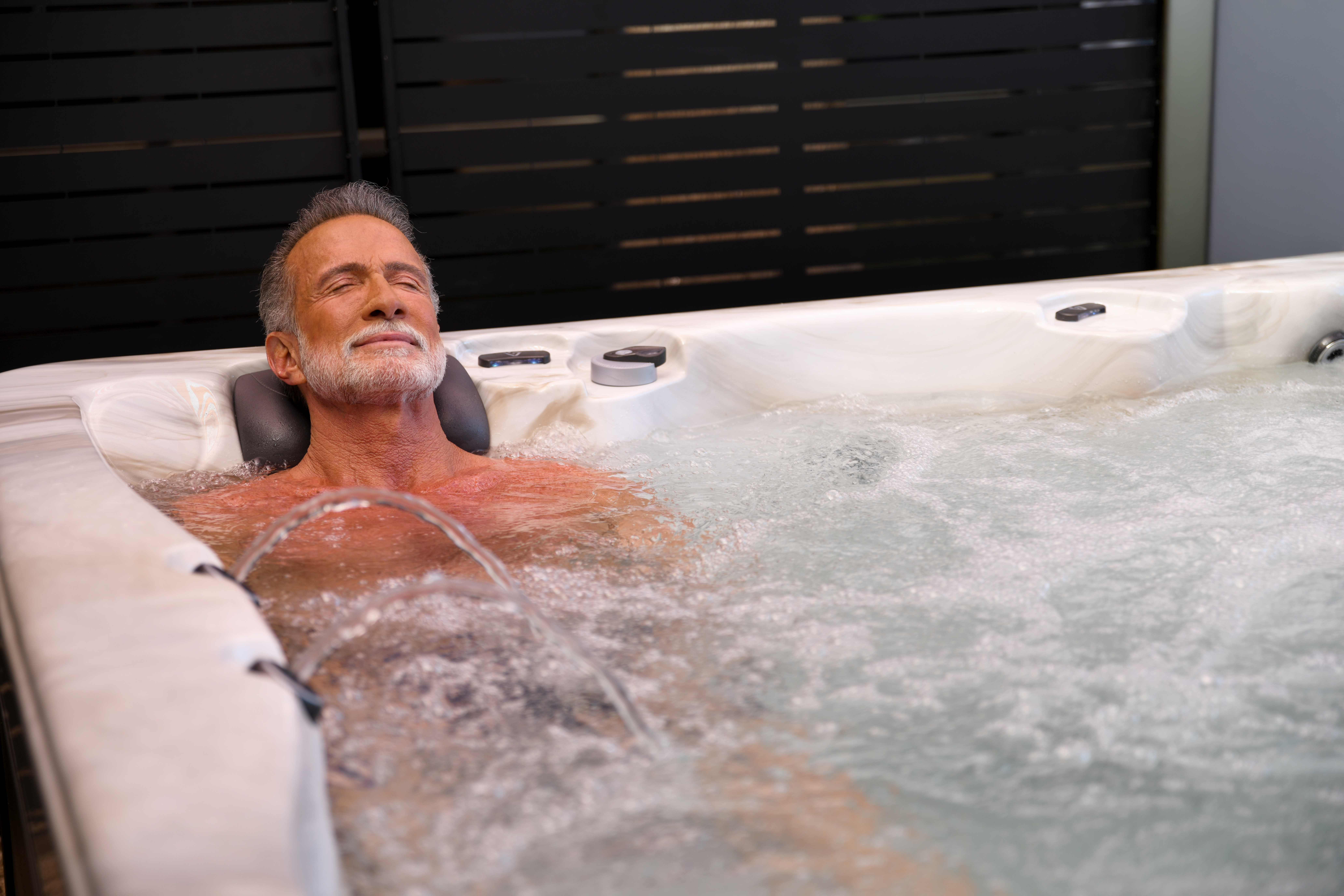 A man relaxing in a Vita Spa hot tub. RnR Hot Tubs and Spas